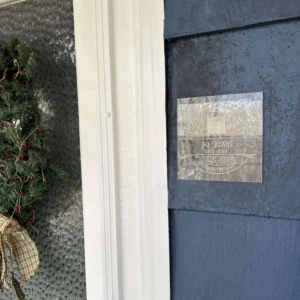 photo of homeowner plaque on exterior siding of a blue home